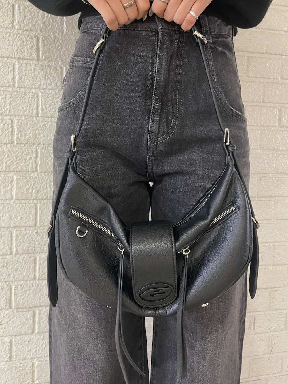 ブラック系のニット/セーター、ブラック系のハンドバッグ、ブラック系のデニムパンツを着用したレディースの冬コーディネートの10枚目の写真