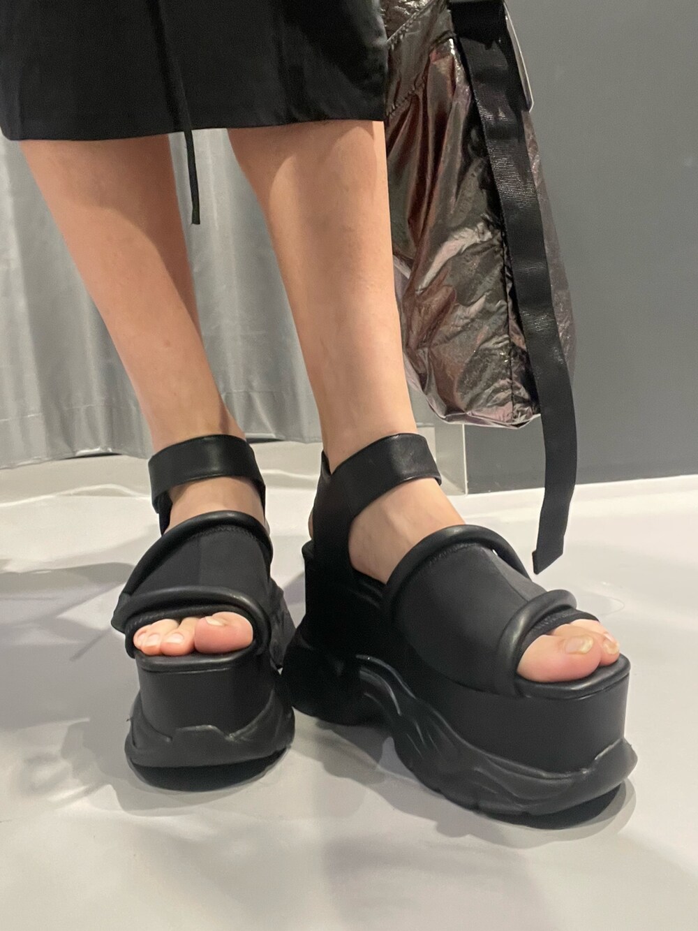 ブラック系のTシャツ/カットソー、ブラック系のハンドバッグ、ホワイト系のカーゴパンツを着用したレディースの春コーディネートの9枚目の写真