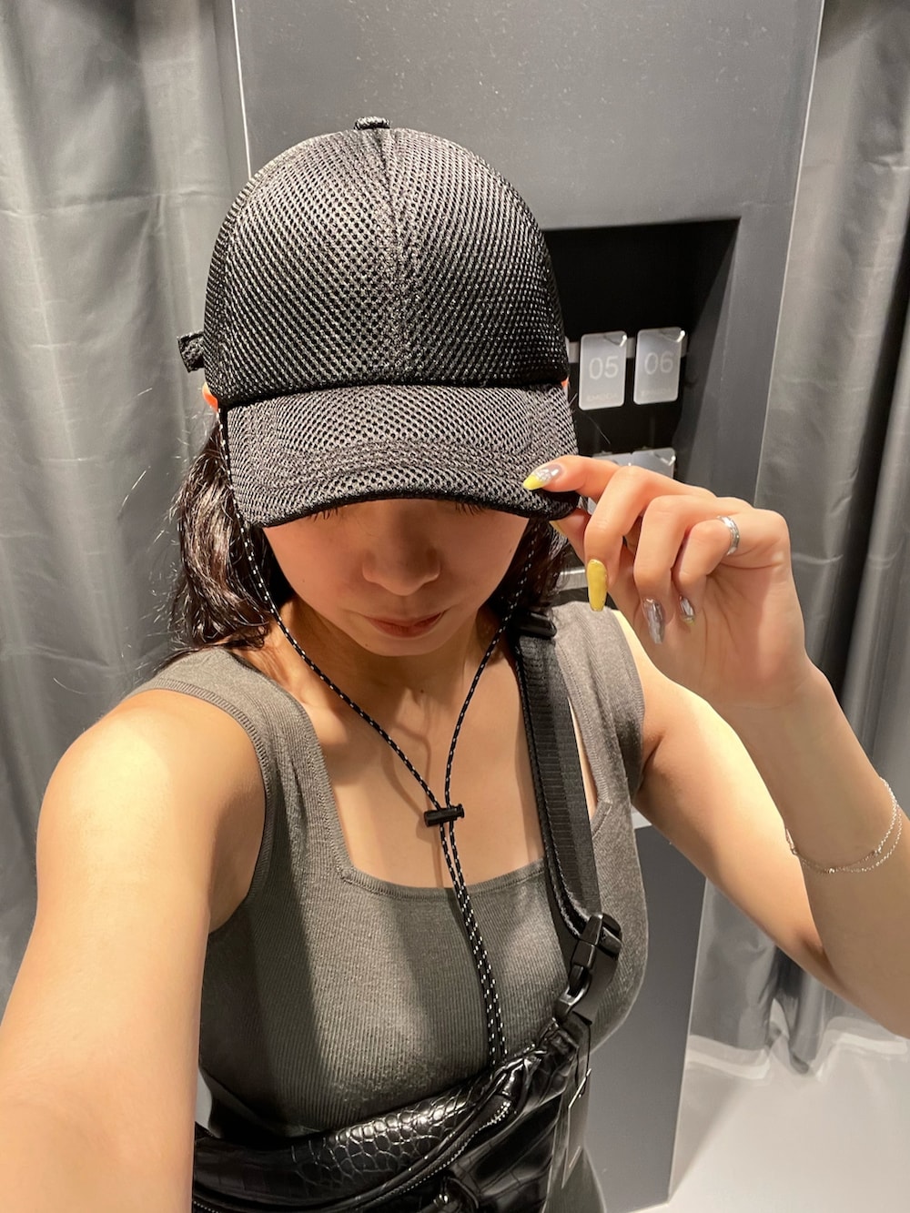 ブラック系のハンドバッグ、グレー系のワンピース、ブラック系のサンダルを着用したレディースの春コーディネートの8枚目の写真