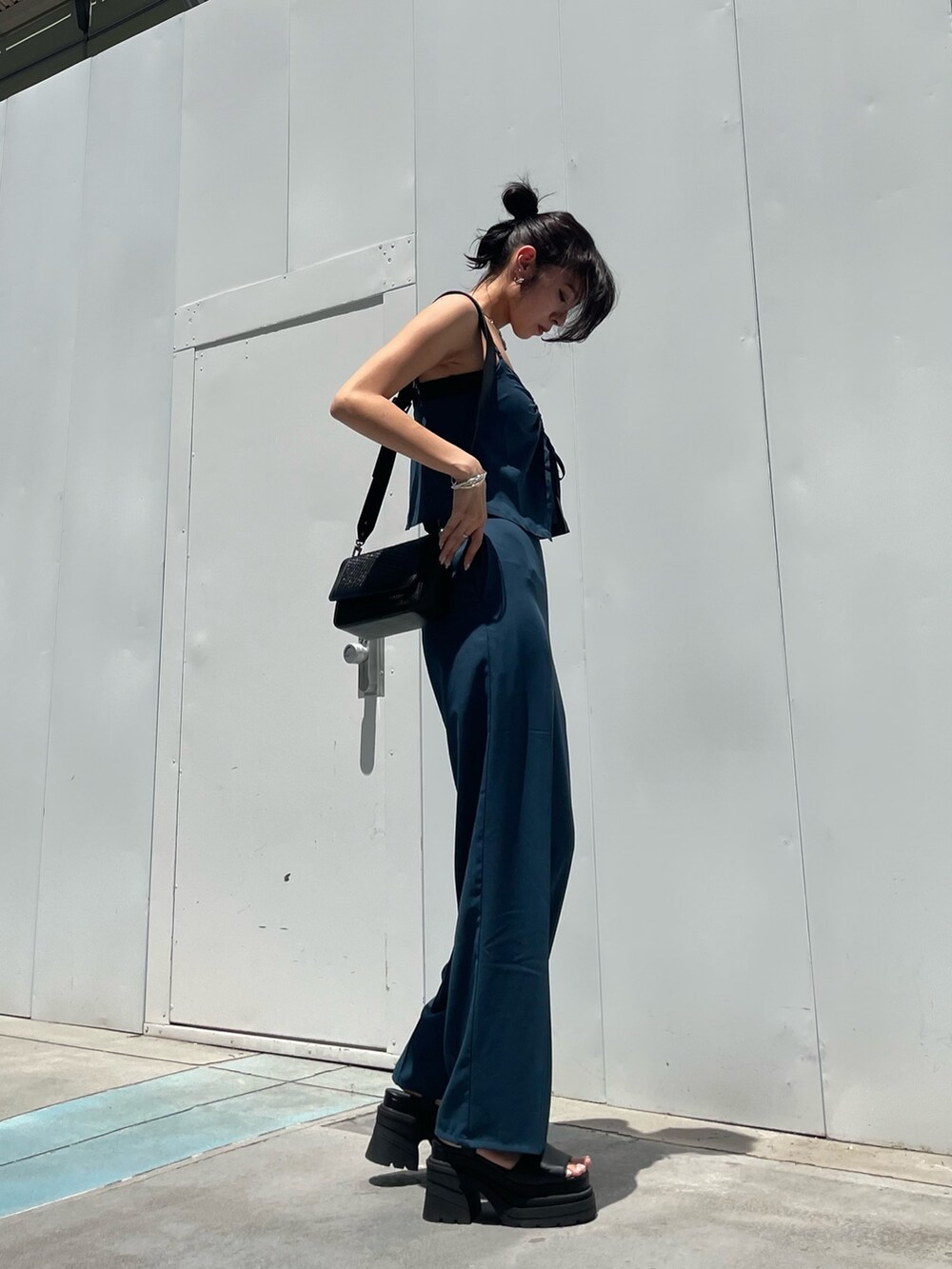 ブルー系のつなぎ/オールインワン、ブラック系のショルダーバッグ、ブラック系のサンダルを着用したレディースの夏コーディネートの2枚目の写真