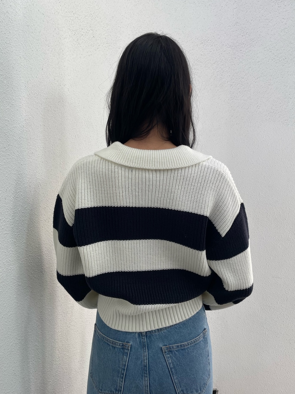 ブラック系のブルゾン、その他のニット/セーター、ブルー系のデニムパンツを着用したレディースの冬コーディネートの8枚目の写真