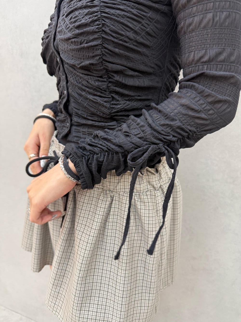 ブラック系のTシャツ/カットソー、ブラック系のスカート、ブラック系のブーツを着用したレディースの冬コーディネートの5枚目の写真