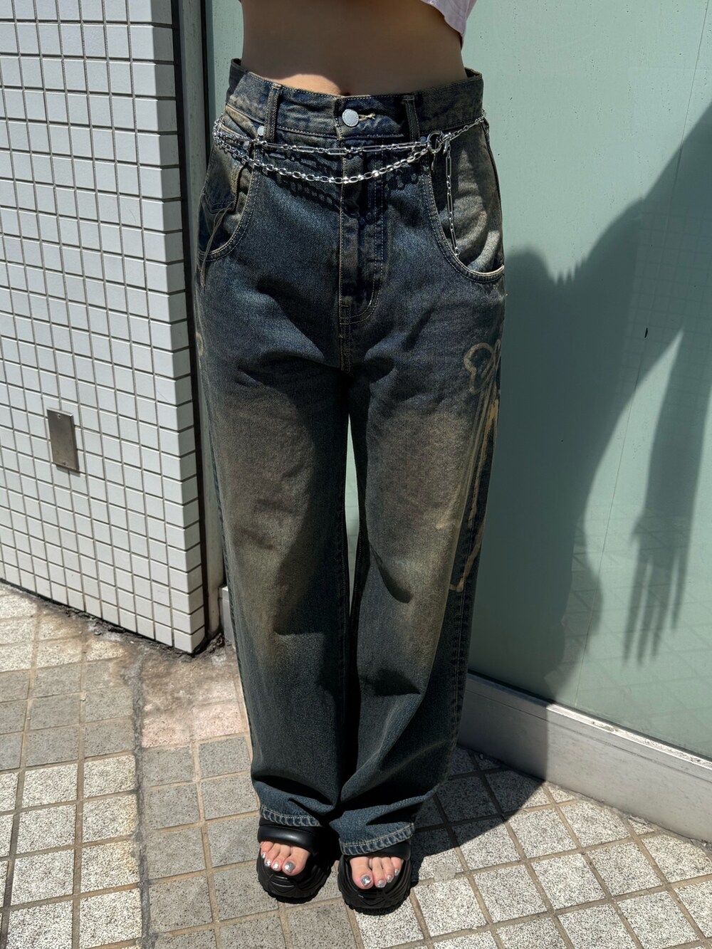 ホワイト系のTシャツ/カットソー、ブルー系のデニムパンツ、ブラック系のブーツを着用したレディースの夏コーディネートの6枚目の写真