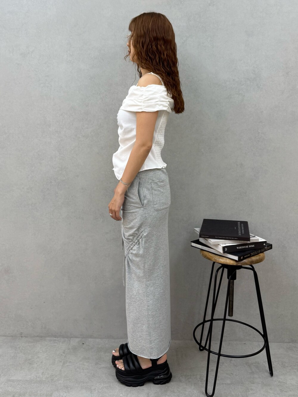 ホワイト系のTシャツ/カットソー、グレー系のスカート、ブラック系のサンダルを着用したレディースの夏コーディネートの2枚目の写真