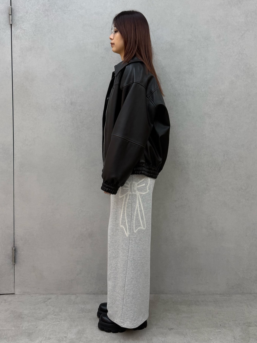 ブラック系のブルゾン、ブラック系のニット/セーター、グレー系のスウェットパンツを着用したレディースの冬コーディネートの2枚目の写真