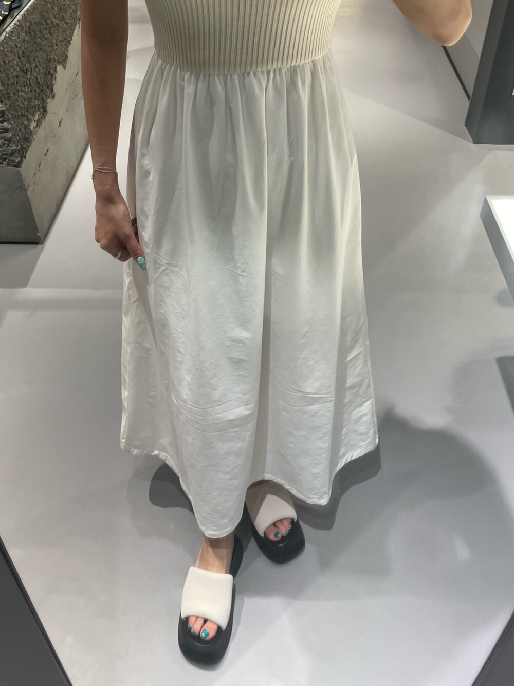 ホワイト系のワンピース、ホワイト系のサンダル、シルバー系のネックレスを着用したレディースの夏コーディネートの6枚目の写真