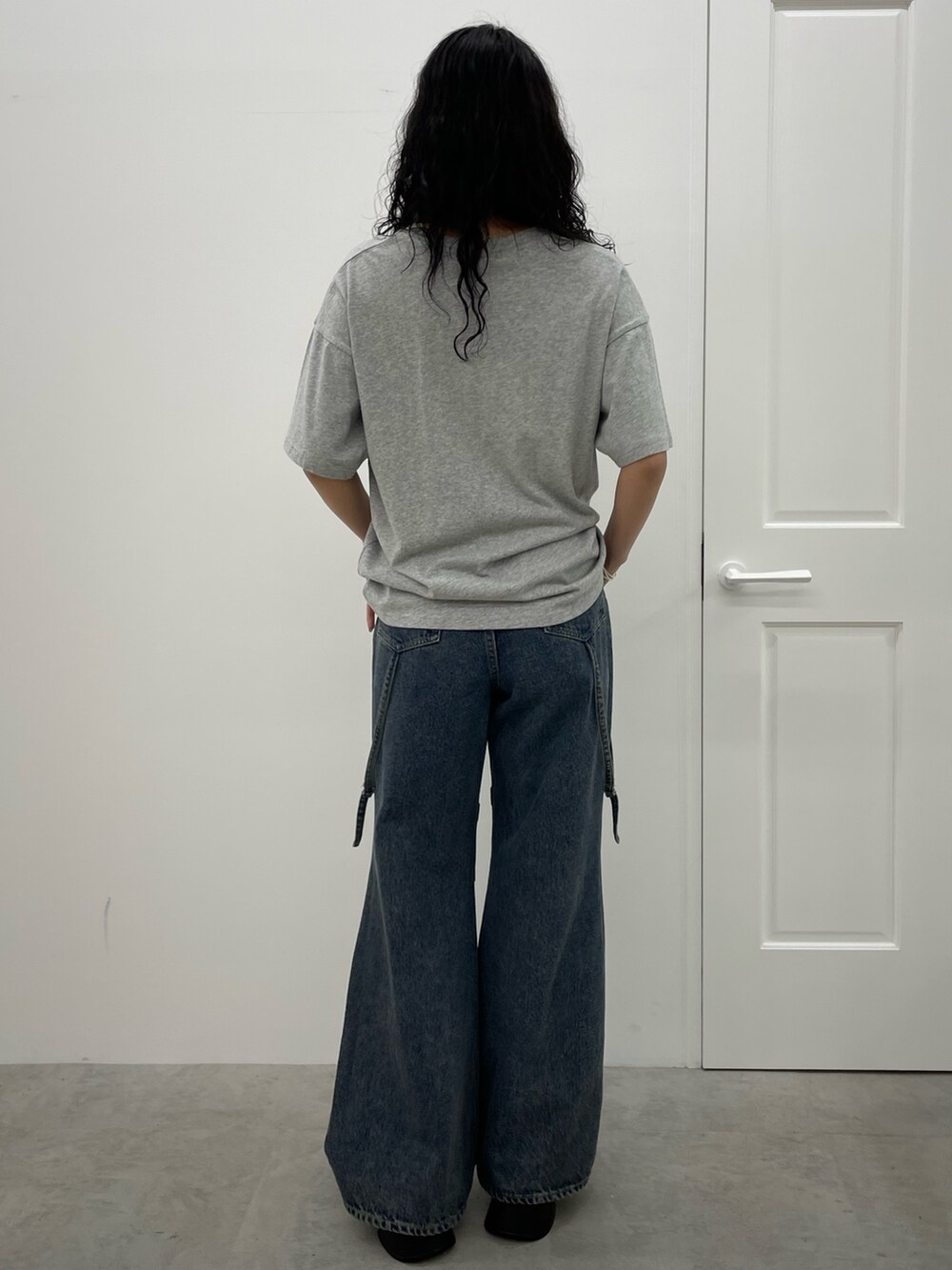 グレー系のTシャツ/カットソー、ブルー系のデニムパンツ、ブラック系のサンダルを着用したレディースの春コーディネートの3枚目の写真