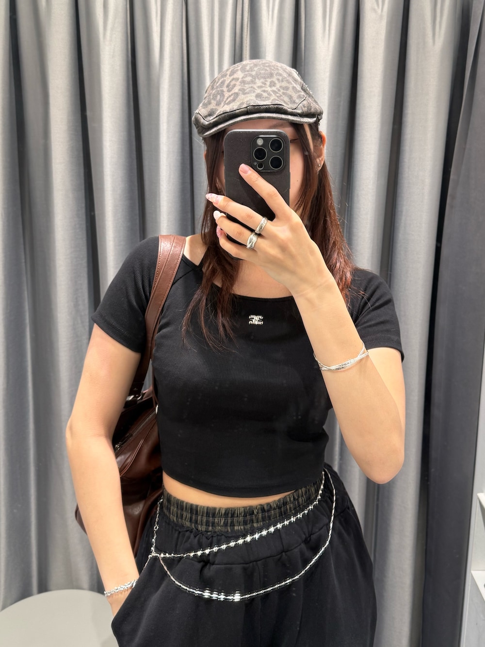 ブラウン系のトートバッグ、ブラック系のスウェットパンツ、ブラック系のスニーカーを着用したレディースの春コーディネートの4枚目の写真