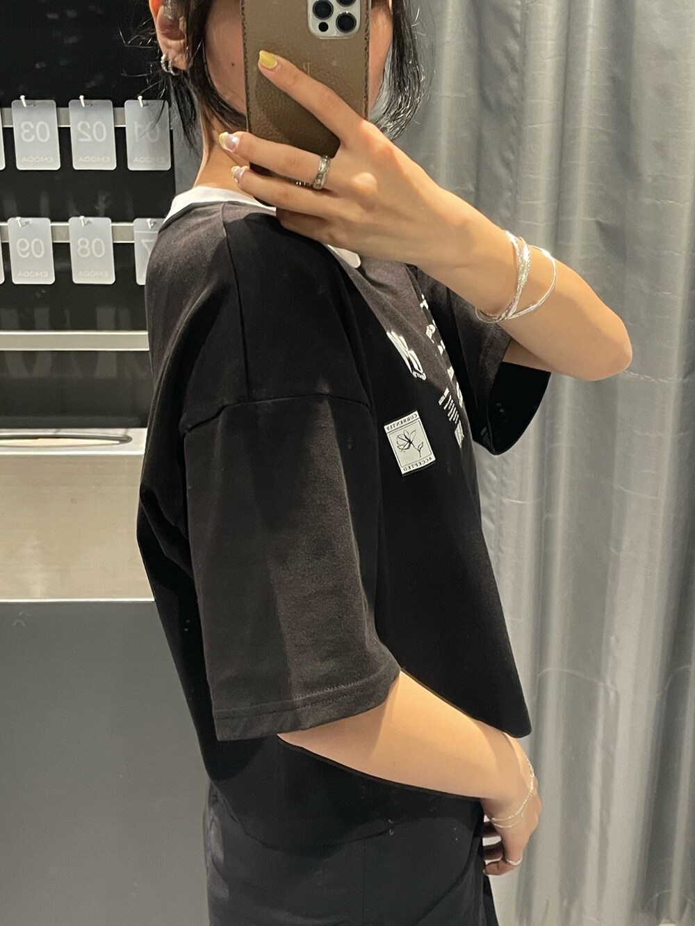 ブラック系のTシャツ/カットソー、ブラック系のハンドバッグ、ホワイト系のカーゴパンツを着用したレディースの春コーディネートの5枚目の写真