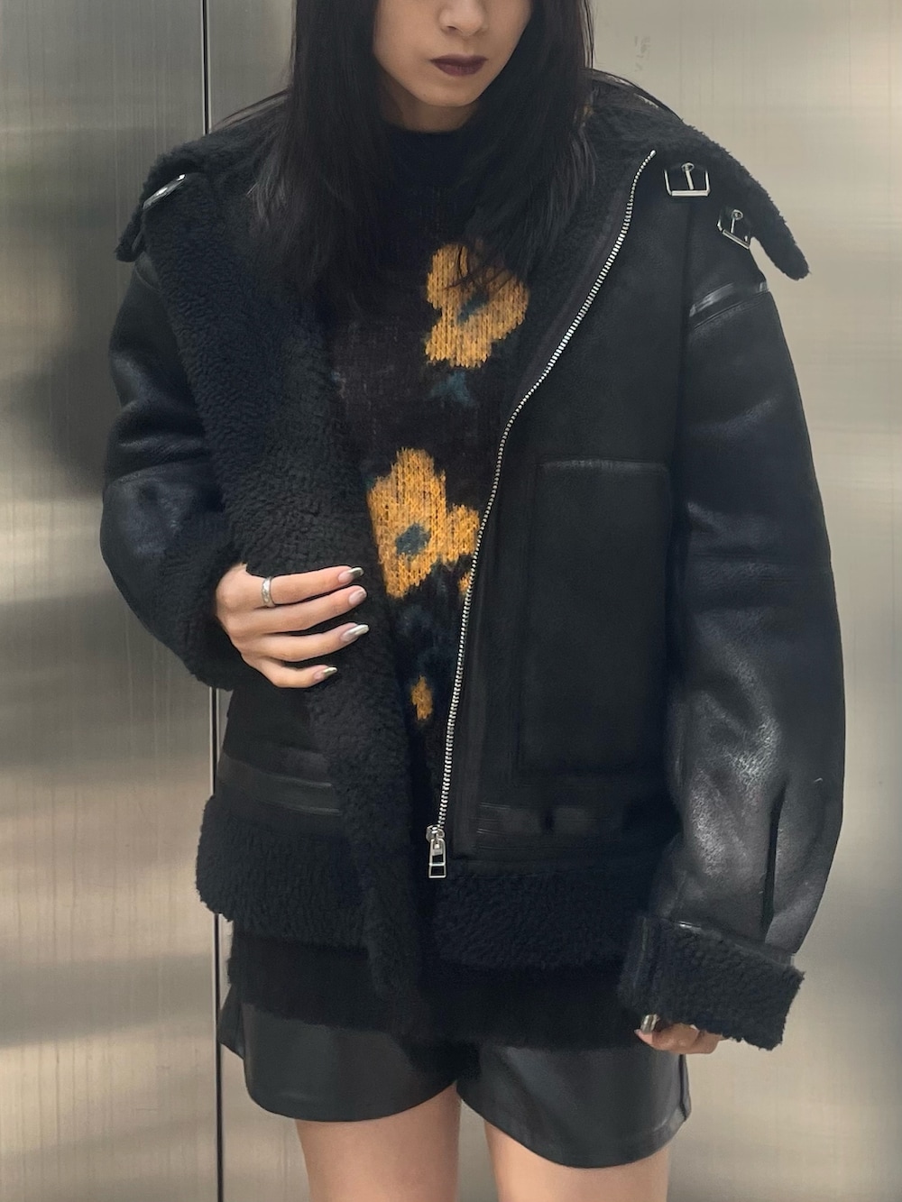 オレンジ系のニット/セーター、ブラック系のムートンコート、ブラック系のその他パンツを着用したレディースの秋コーディネートの4枚目の写真