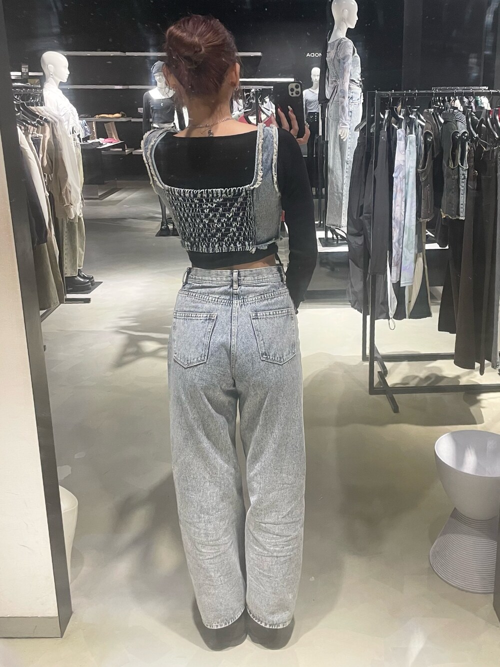 ブラック系のTシャツ/カットソー、ブルー系のデニムパンツ、ブラック系のブーツを着用したレディースの春コーディネートの3枚目の写真