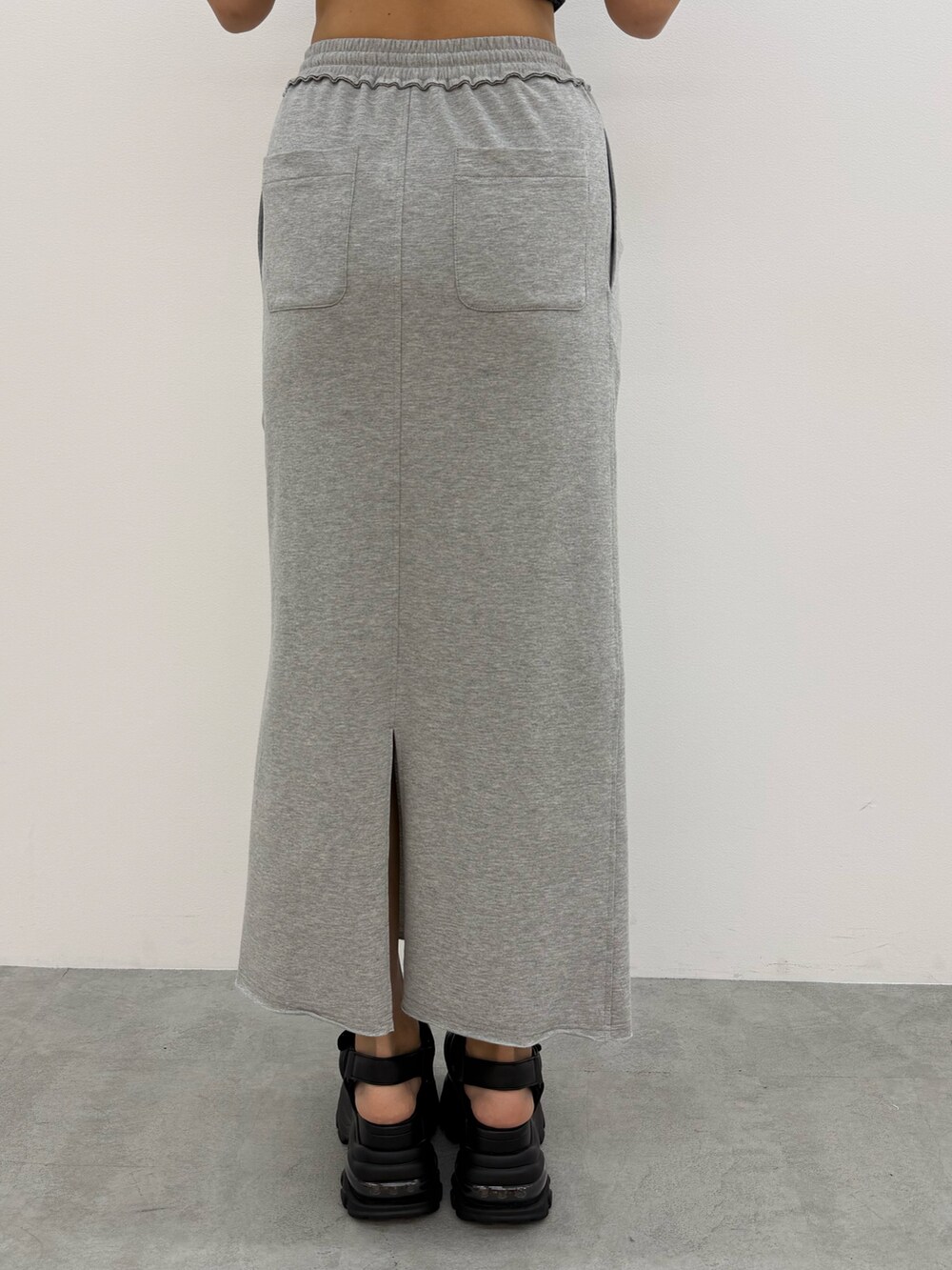 ホワイト系のTシャツ/カットソー、グレー系のスカート、ブラック系のサンダルを着用したレディースの夏コーディネートの9枚目の写真