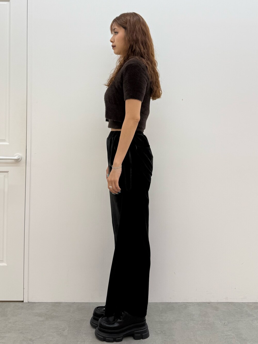 ブラウン系のニット/セーター、ブラック系のその他パンツ、ブラック系のローファーを着用したレディースの夏コーディネートの2枚目の写真