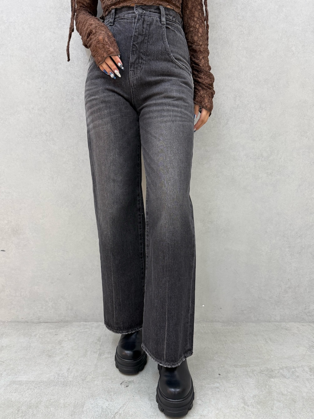 レッド系のパーカー、ブラック系のデニムパンツ、ブラック系のブーツを着用したレディースの秋コーディネートの5枚目の写真