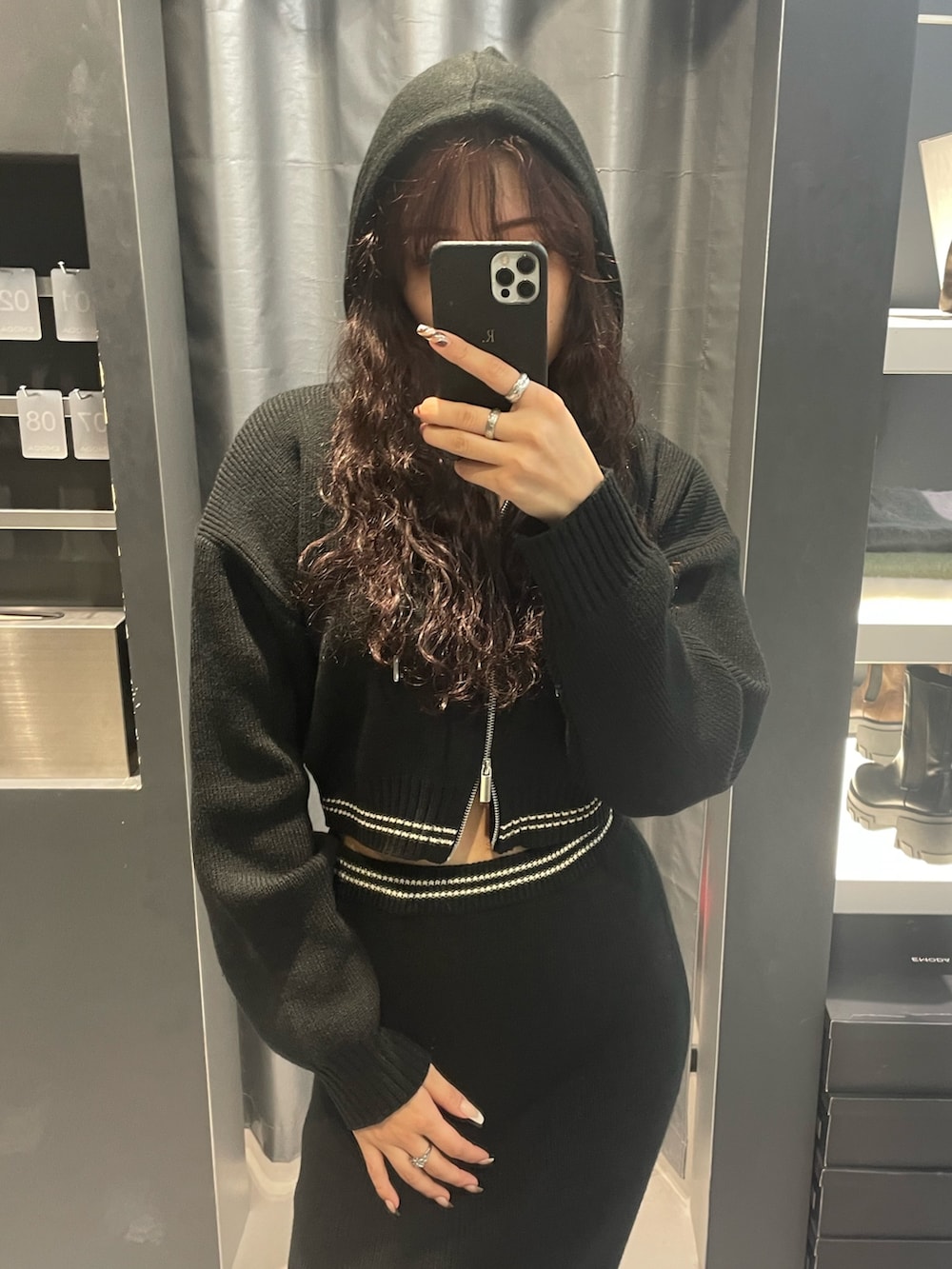 ブラック系のニット/セーター、ブラック系のスカート、シルバー系のブーツを着用したレディースの冬コーディネートの4枚目の写真