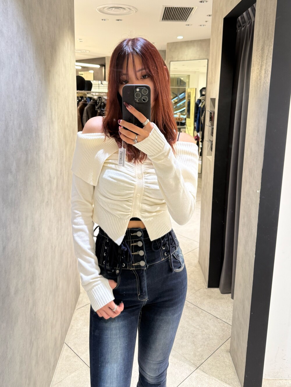 ホワイト系のニット/セーター、ブルー系のデニムパンツ、ブラック系のブーツを着用したレディースの秋コーディネートの4枚目の写真