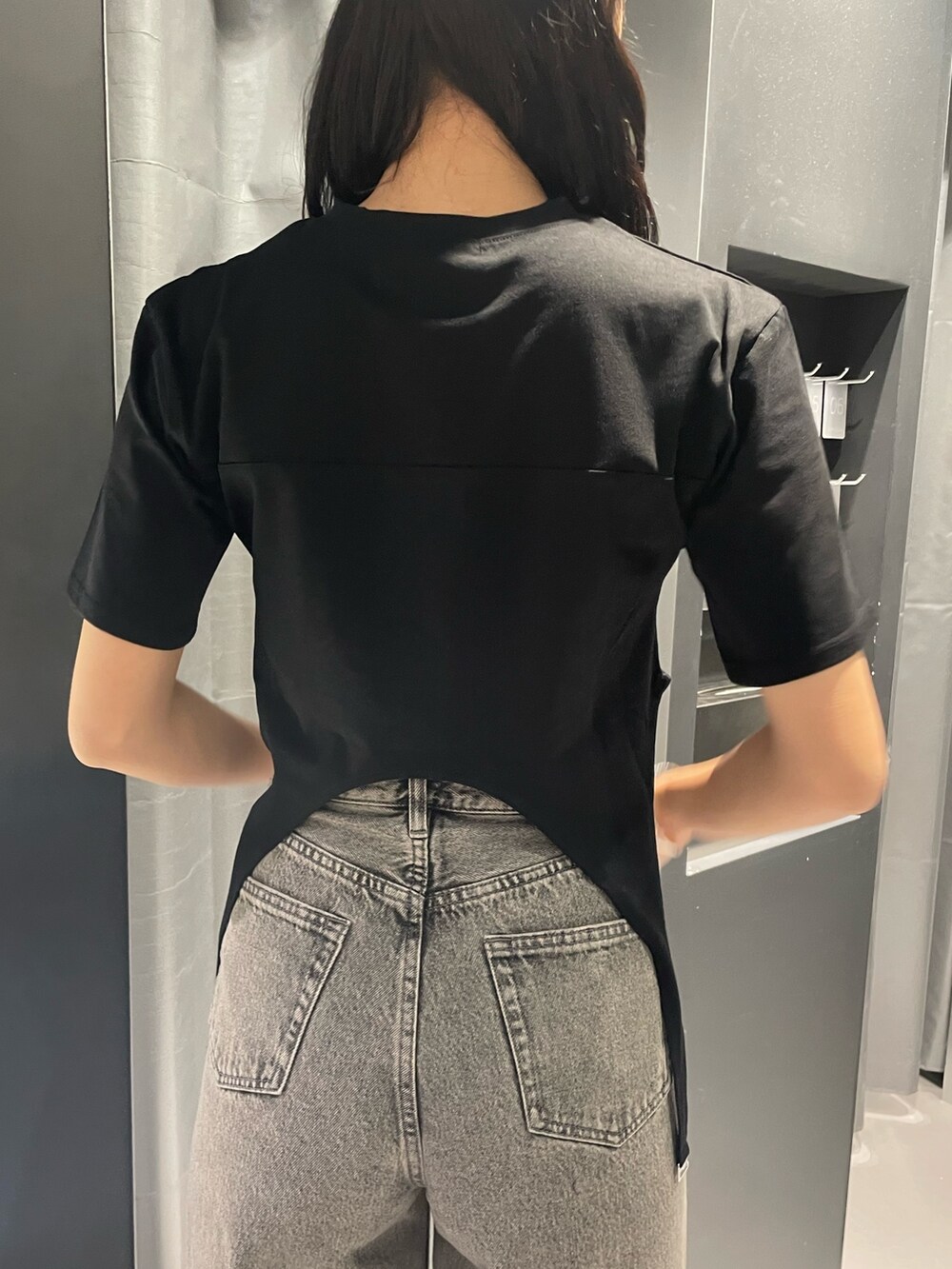 ブラック系のサンダル、ブラック系のTシャツ/カットソー、グレー系のデニムパンツを着用したレディースの春コーディネートの6枚目の写真