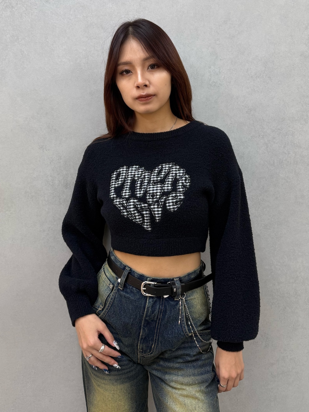 ブラック系のニット/セーター、ブルー系のデニムパンツ、ブラック系のブーツを着用したレディースの冬コーディネートの4枚目の写真