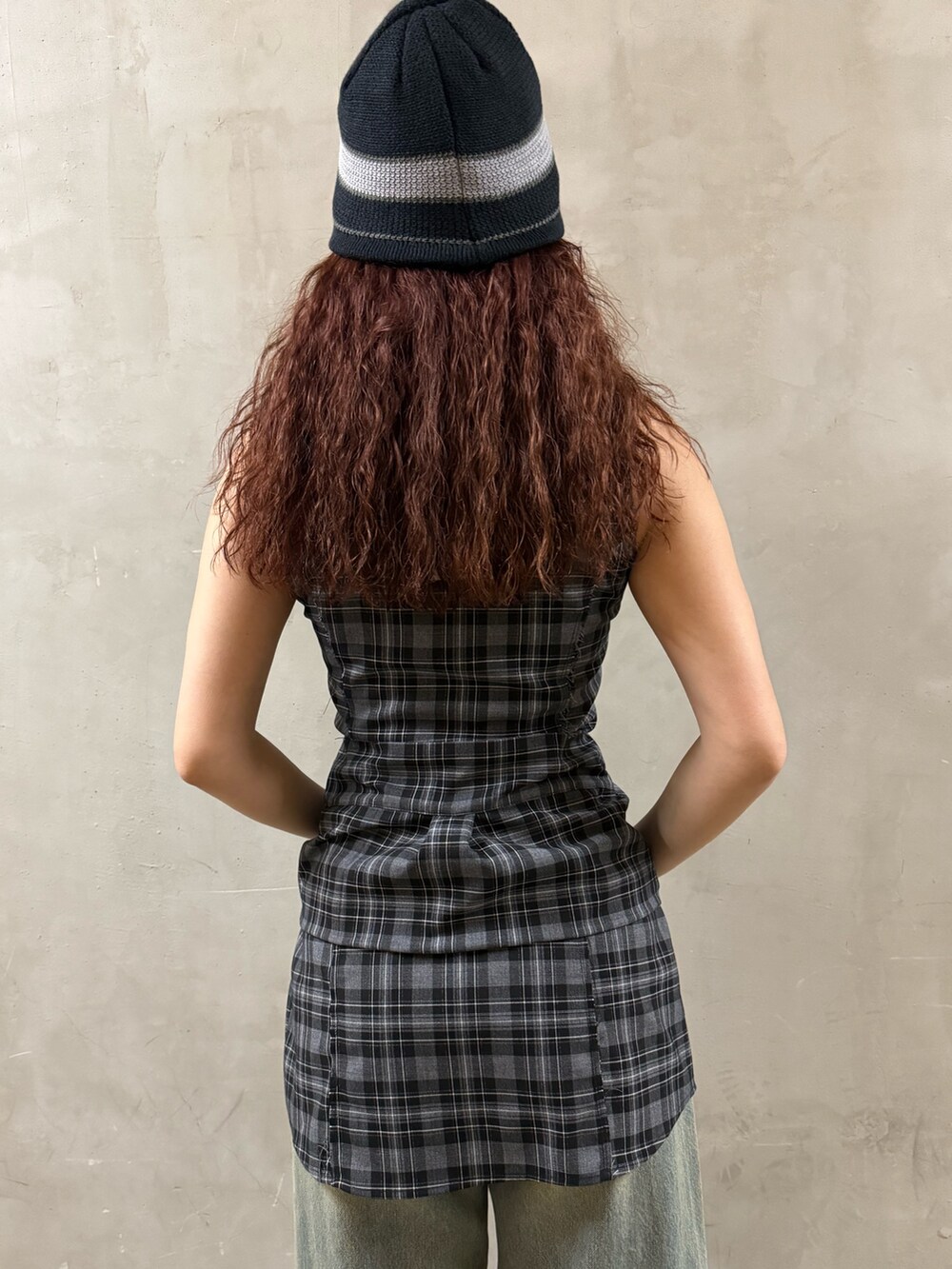 グレー系のワンピース、ブルー系のデニムパンツ、ブラック系のサンダルを着用したレディースの夏コーディネートの6枚目の写真