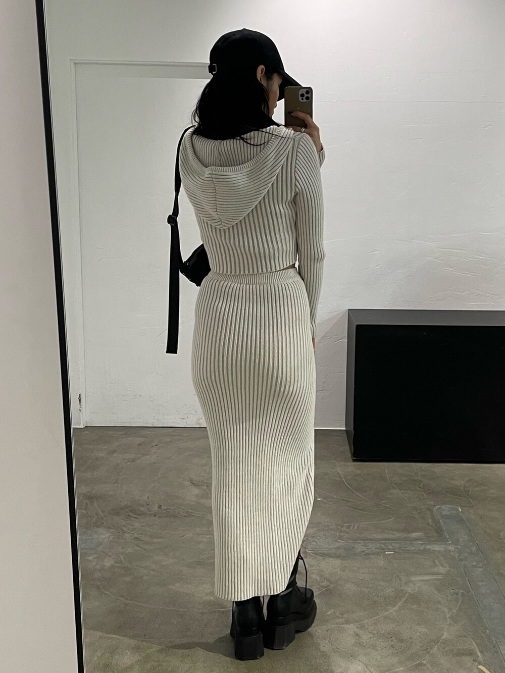 ホワイト系のワンピース、ブラック系のキャミソール、ブラック系のブーツを着用したレディースの春コーディネートの7枚目の写真