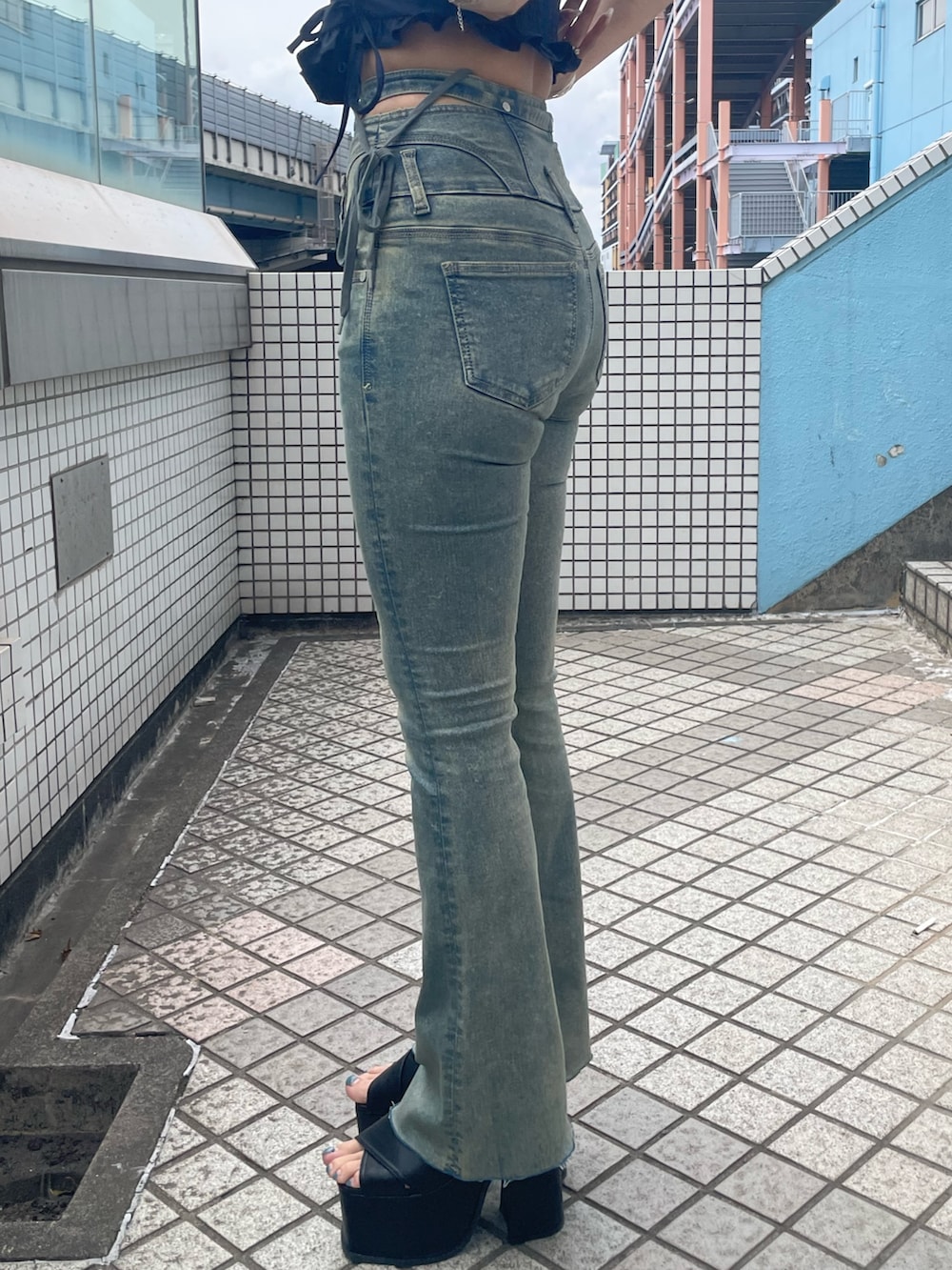 ホワイト系のTシャツ/カットソー、ブルー系のデニムパンツ、ブラック系のサンダルを着用したレディースの春コーディネートの8枚目の写真