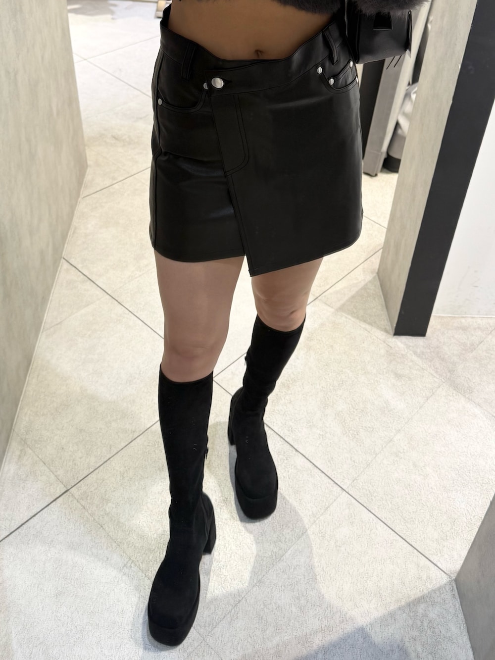 ブラウン系のニット/セーター、ブラック系のスカート、ブラック系のブーツを着用したレディースの秋コーディネートの6枚目の写真