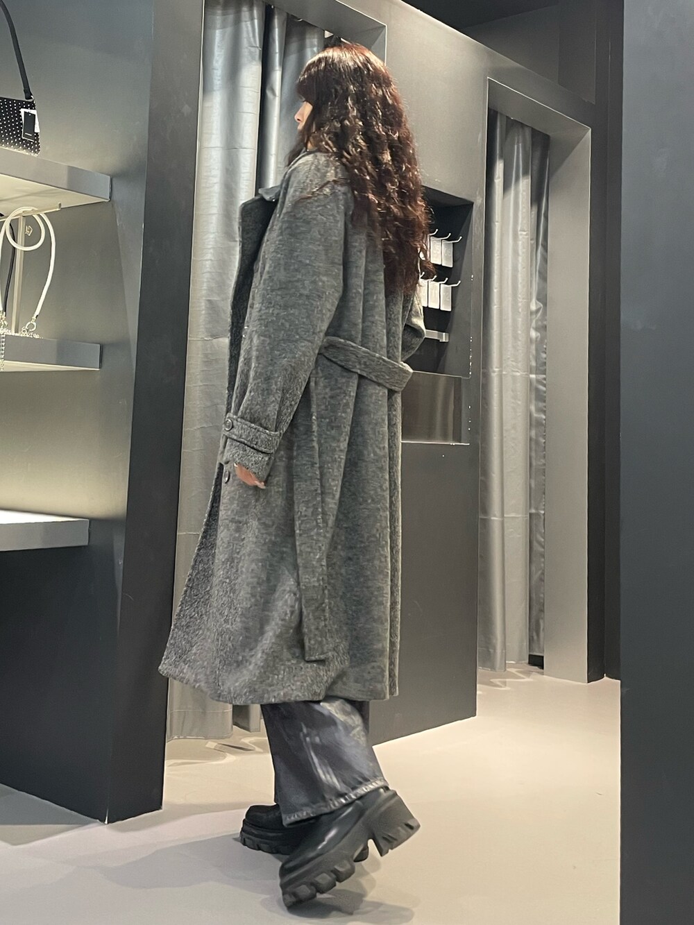 ブラック系のニット/セーター、グレー系のその他アウター、ブルー系のデニムパンツを着用したレディースの冬コーディネートの2枚目の写真