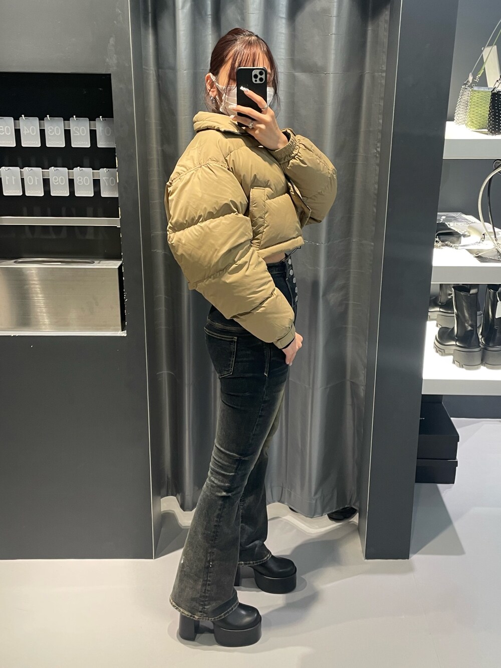 ブラック系のニット/セーター、ベージュ系のブルゾン、ブルー系のデニムパンツを着用したレディースの冬コーディネートの2枚目の写真