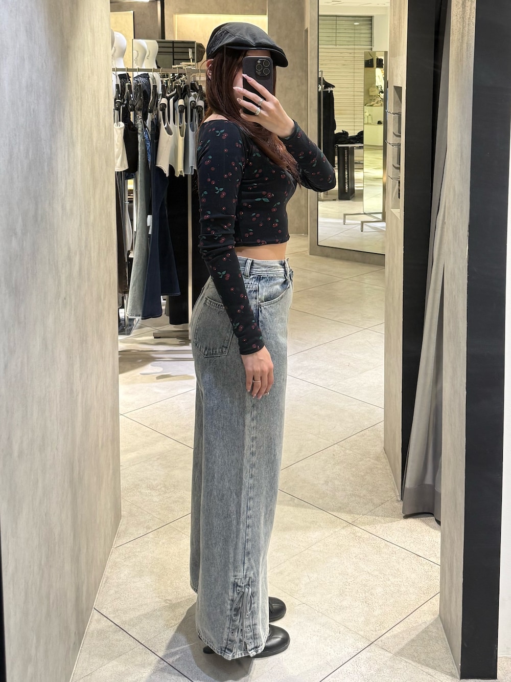 ブラック系のTシャツ/カットソー、ブルー系のデニムパンツ、ブラック系のスニーカーを着用したレディースの春コーディネートの2枚目の写真