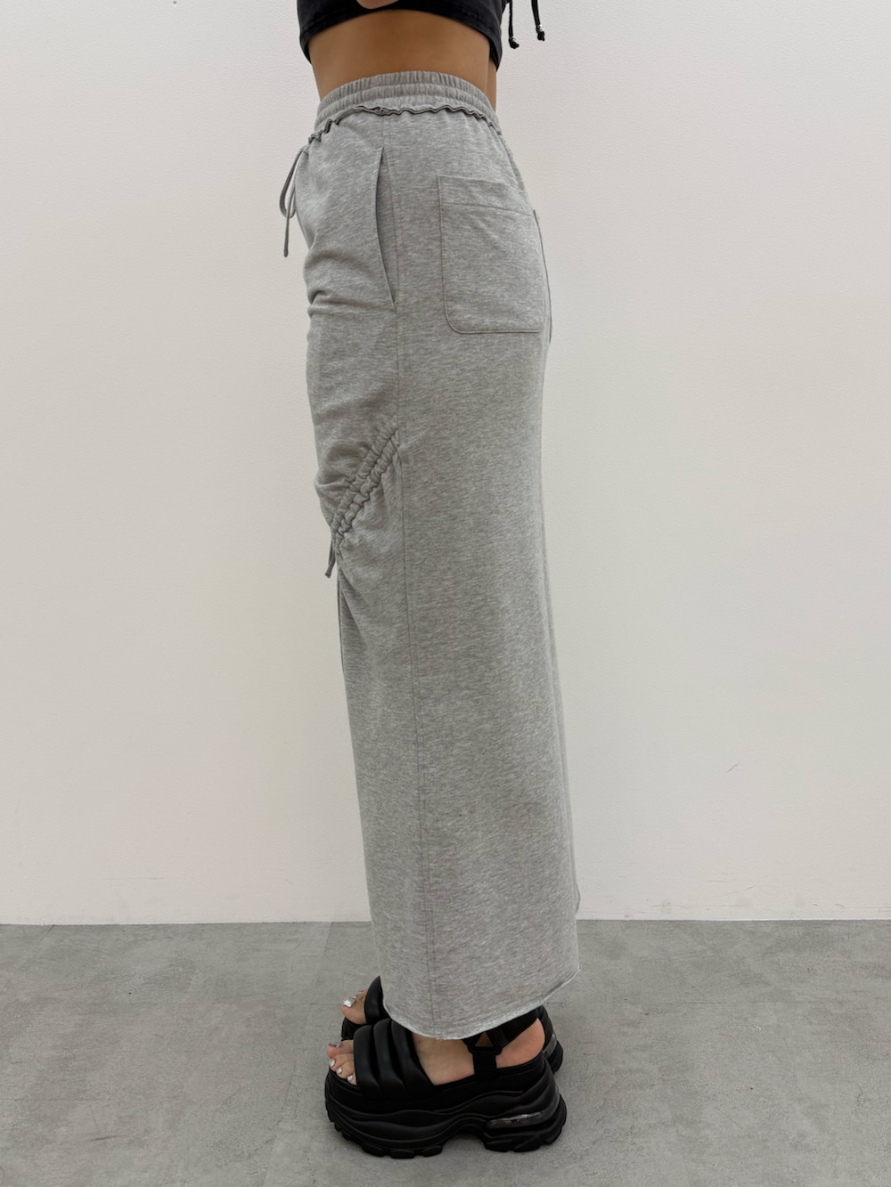 ブラック系のTシャツ/カットソー、グレー系のスカート、ブラック系のサンダルを着用したレディースの夏コーディネートの8枚目の写真