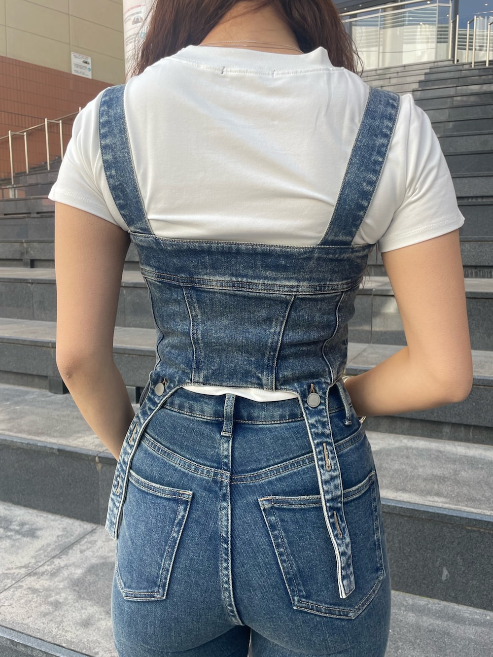 ホワイト系のTシャツ/カットソー、ブルー系のサロペット/オーバーオール、ブラック系のハンドバッグを着用したレディースの春コーディネートの6枚目の写真