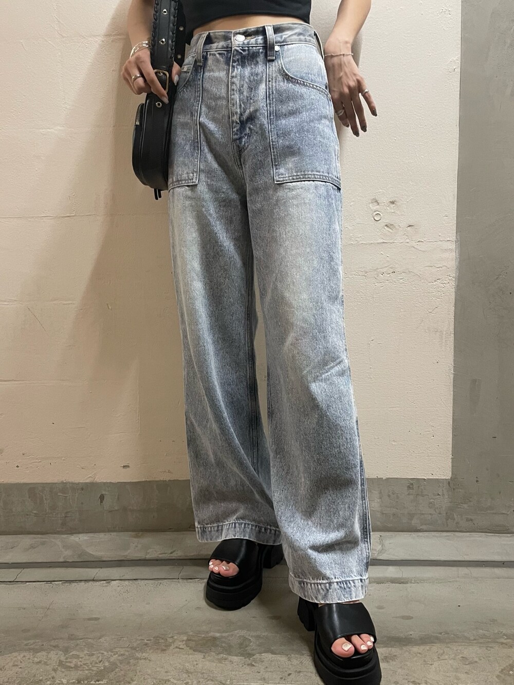 ブラック系のTシャツ/カットソー、ブラック系のショルダーバッグ、ブルー系のデニムパンツを着用したレディースの夏コーディネートの4枚目の写真