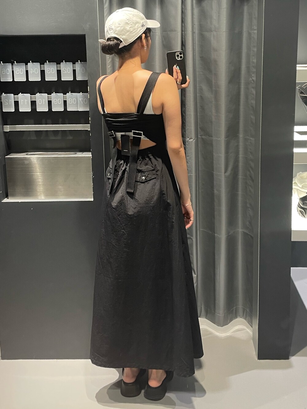 ブラック系のワンピース、ブラック系のサンダル、シルバー系のネックレスを着用したレディースの夏コーディネートの3枚目の写真