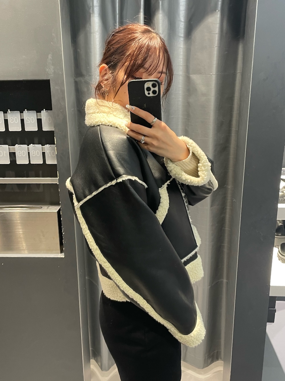 ホワイト系のニット/セーター、ブラック系のスカート、ブラック系のブルゾンを着用したレディースの冬コーディネートの5枚目の写真