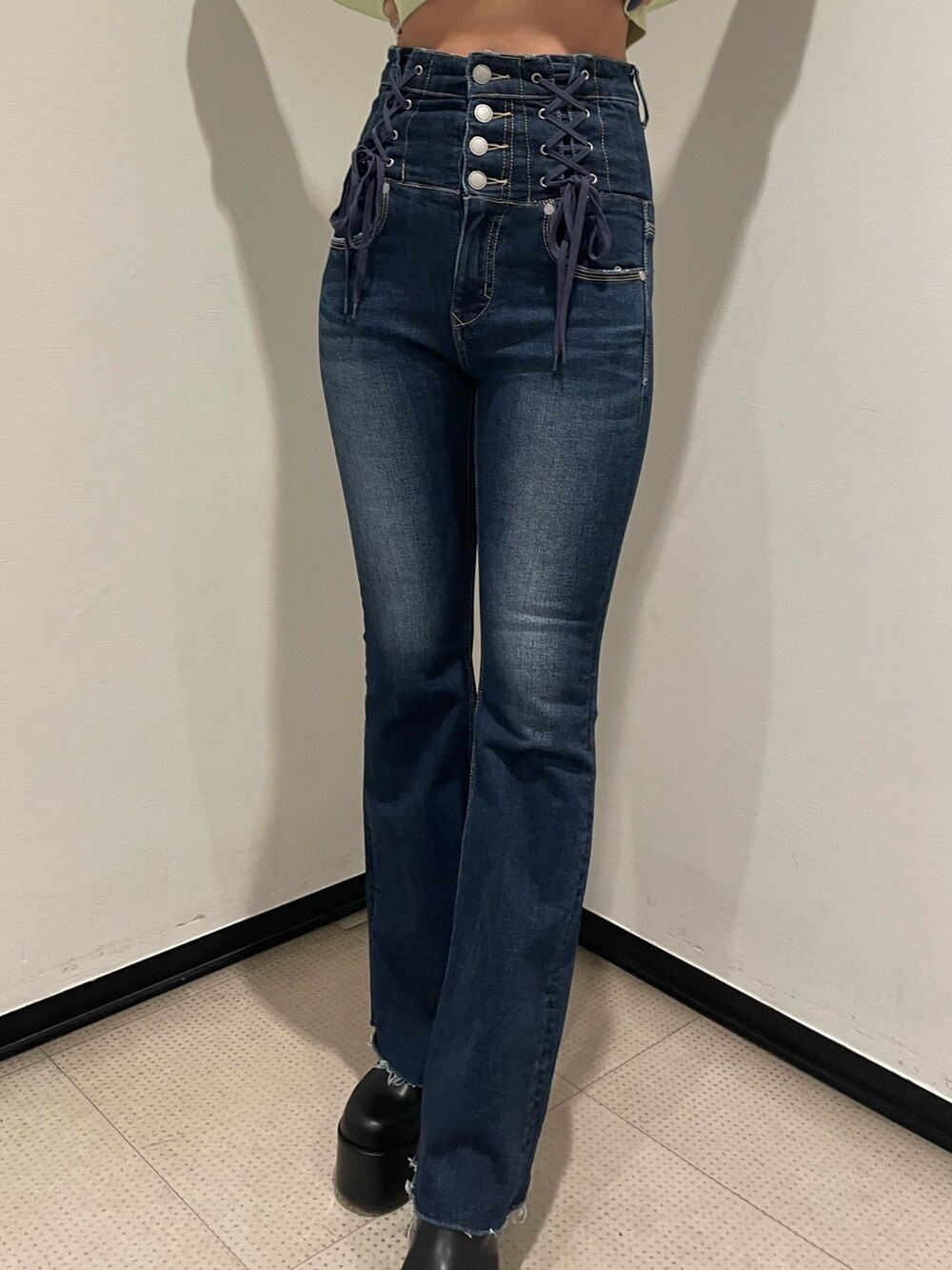 グリーン系のニット/セーター、ブルー系のデニムパンツ、ブラック系のブーツを着用したレディースの冬コーディネートの7枚目の写真