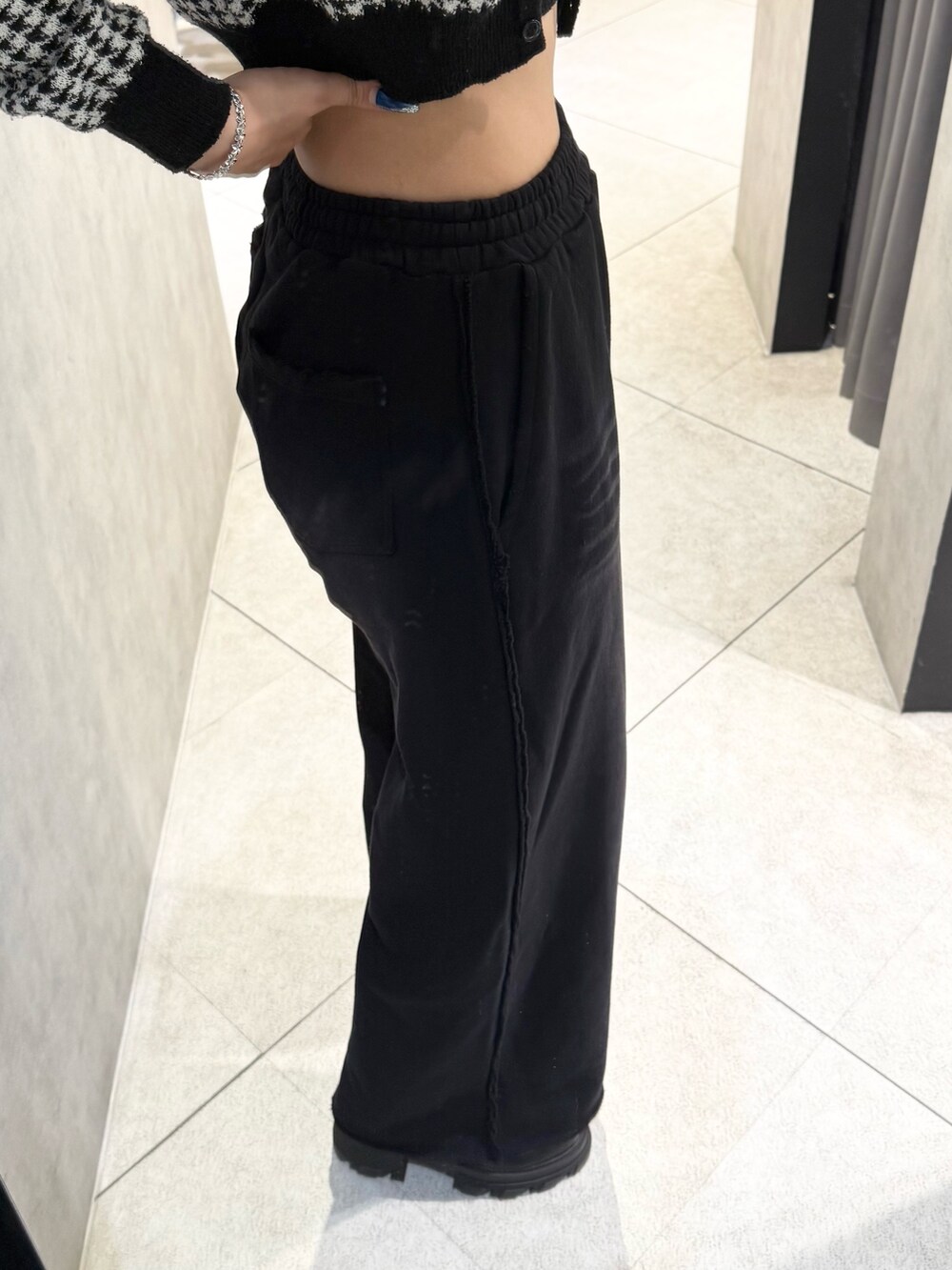 ブラック系のニット/セーター、ブラック系のスウェットパンツ、ブラック系のブーツを着用したレディースの秋コーディネートの7枚目の写真