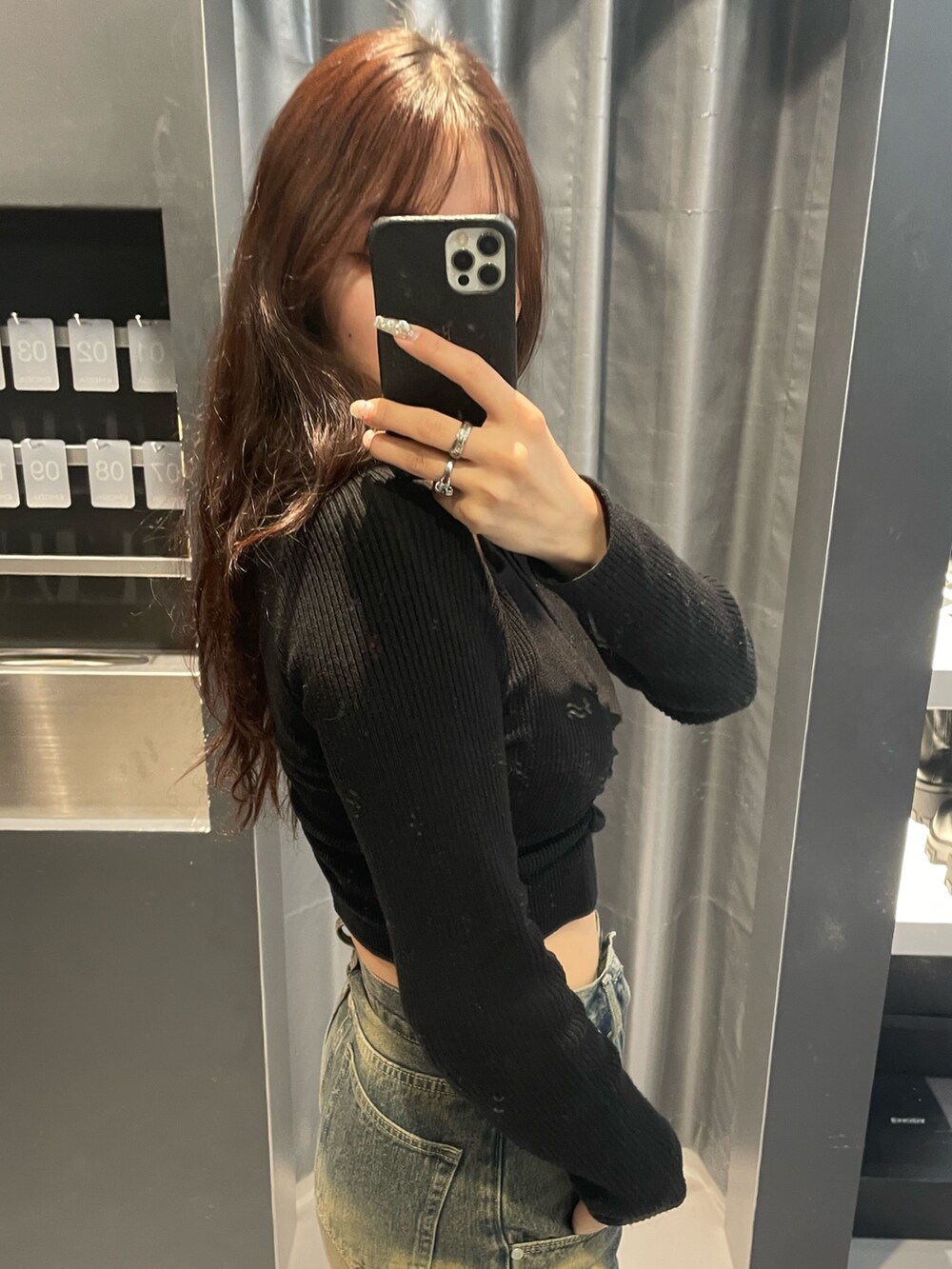 ブラック系のニット/セーター、ブルー系のデニムパンツ、ブラック系のブーツを着用したレディースの冬コーディネートの5枚目の写真