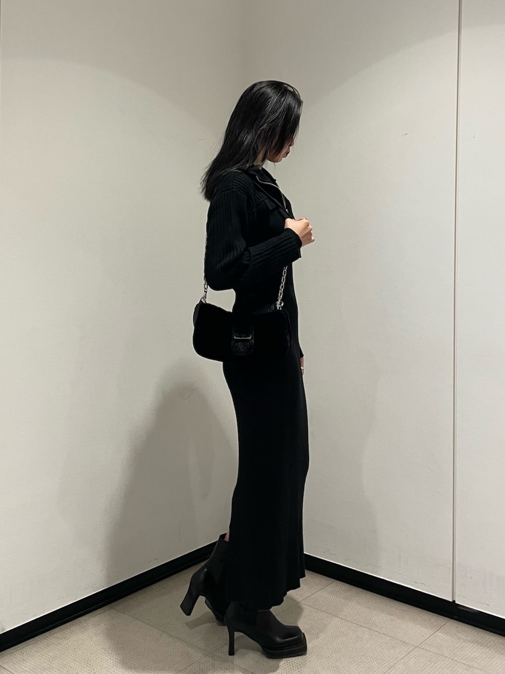 ブラック系のワンピース、ブラック系のハンドバッグ、ブラック系のブーツを着用したレディースの秋コーディネートの2枚目の写真