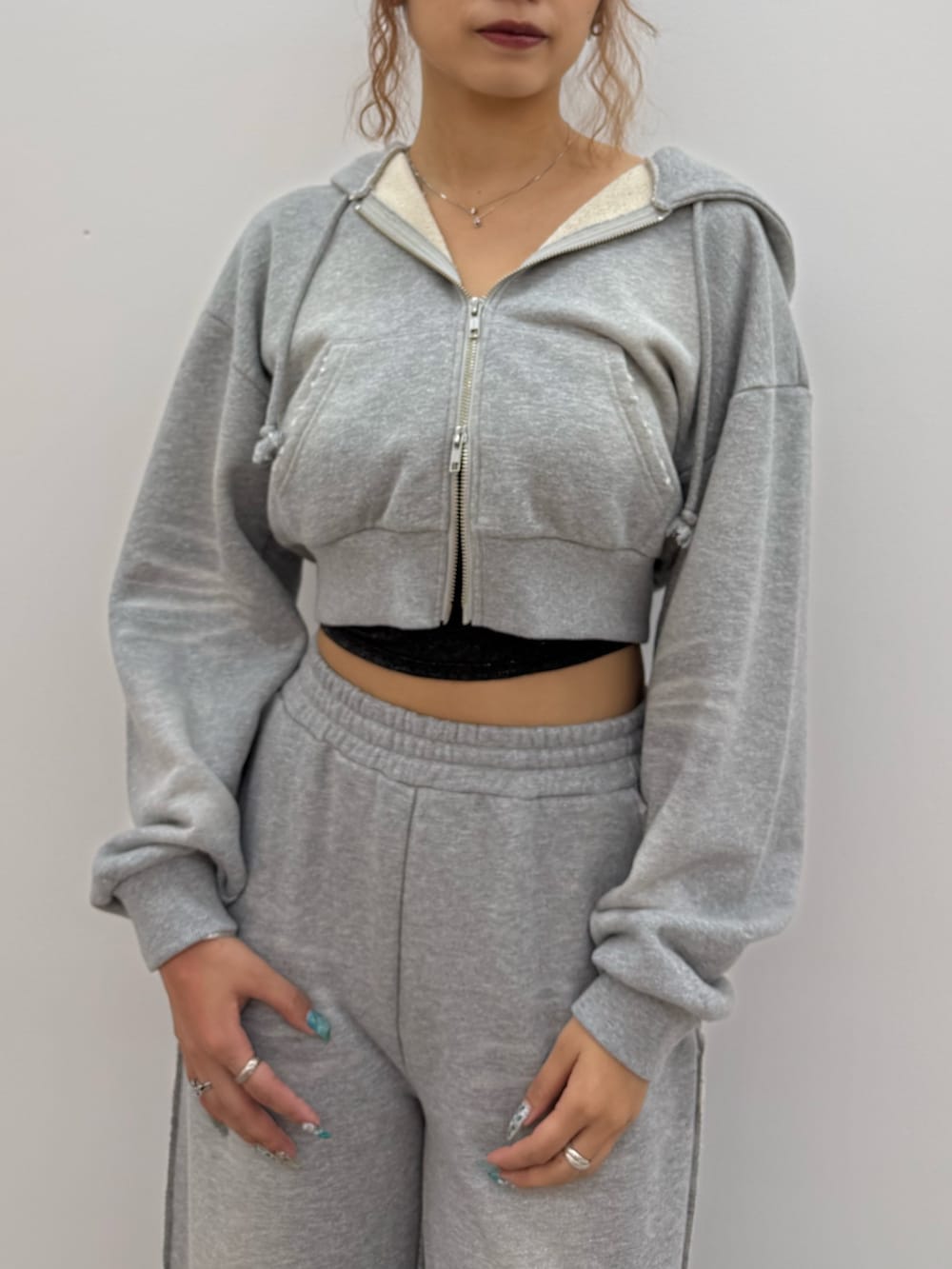 グレー系のパーカー、ブラック系のキャミソール、グレー系のスウェットパンツを着用したレディースの夏コーディネートの4枚目の写真