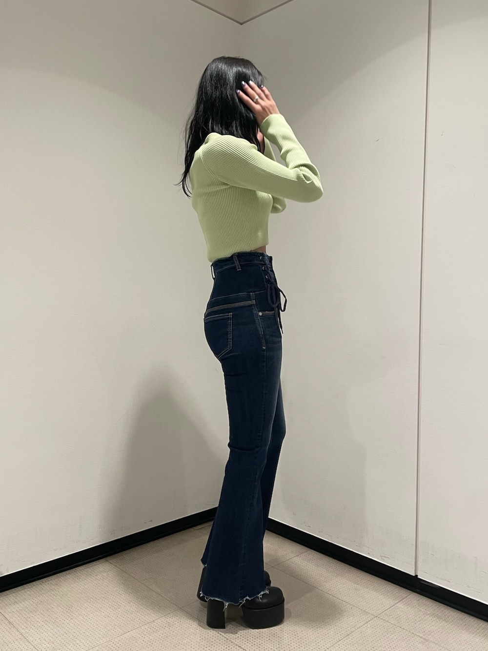 グリーン系のニット/セーター、ブルー系のデニムパンツ、ブラック系のブーツを着用したレディースの冬コーディネートの2枚目の写真