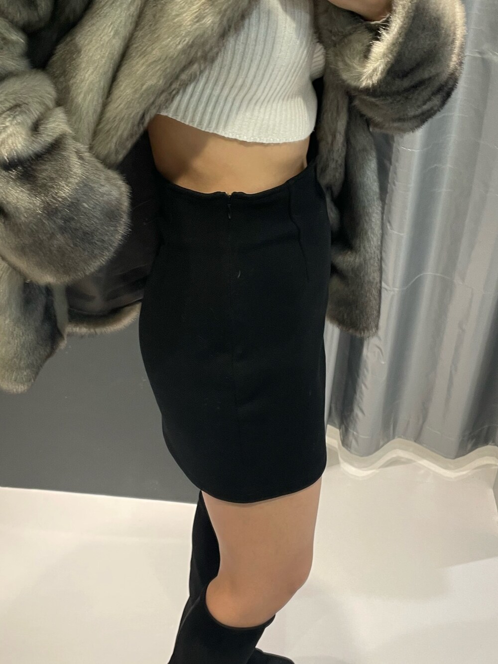 ホワイト系のニット/セーター、グレー系のその他アウター、ブラック系のスカートを着用したレディースの冬コーディネートの8枚目の写真