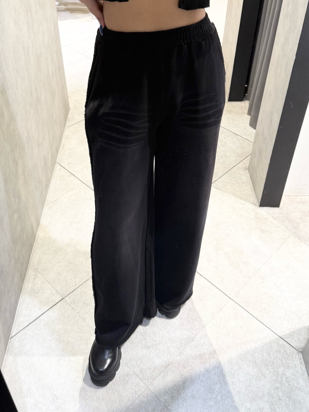 ブラック系のニット/セーター、ブラック系のスウェットパンツ、ブラック系のブーツを着用したレディースの秋コーディネートの6枚目の写真