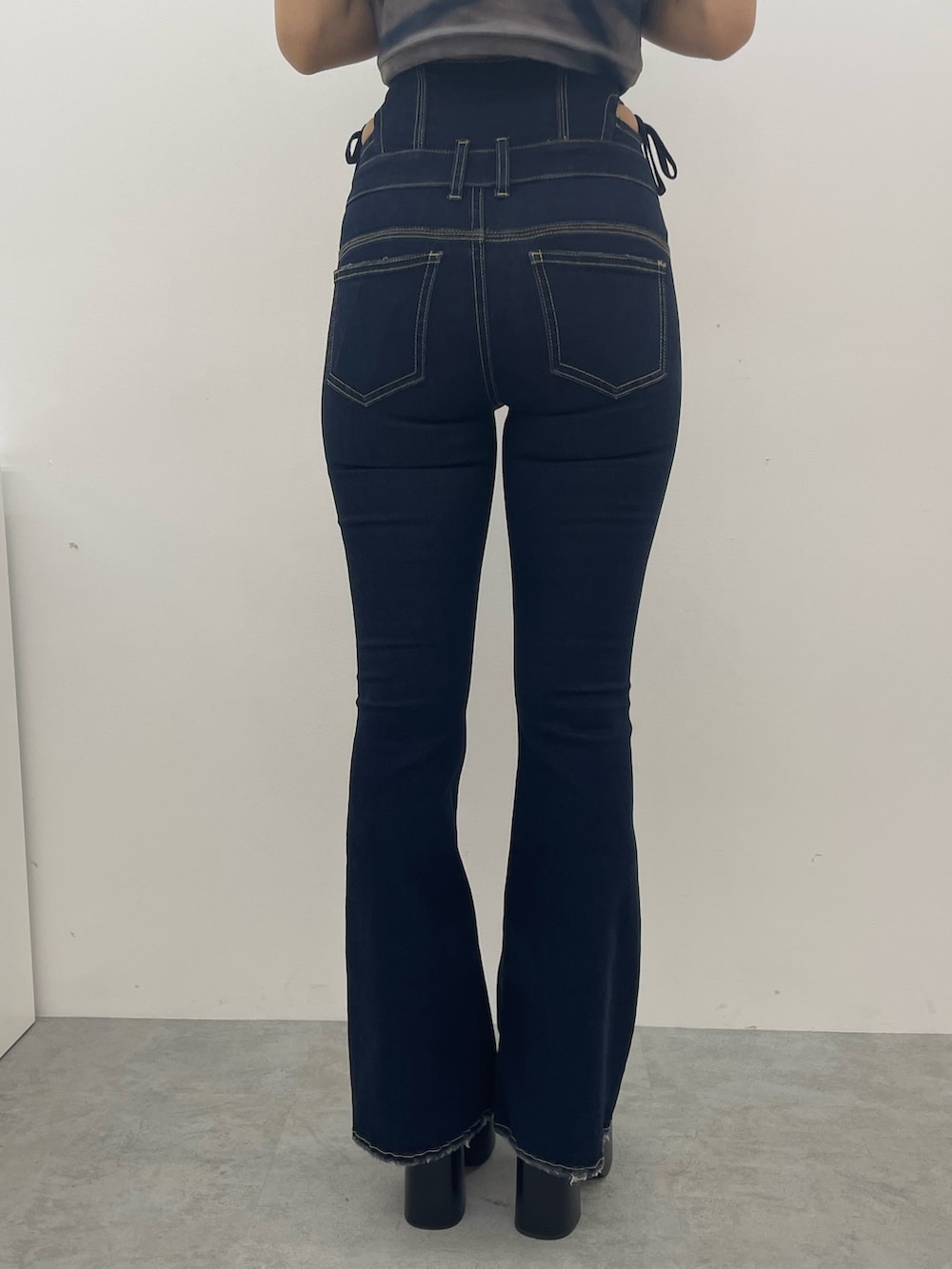 ブルー系のニット/セーター、ブルー系のデニムパンツ、ブラック系のブーツを着用したレディースの夏コーディネートの9枚目の写真