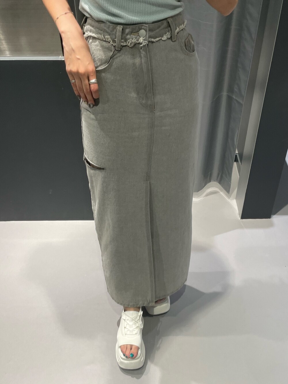 ブラック系のTシャツ/カットソー、グレー系のデニムスカート、ブラック系のサンダルを着用したレディースの夏コーディネートの6枚目の写真