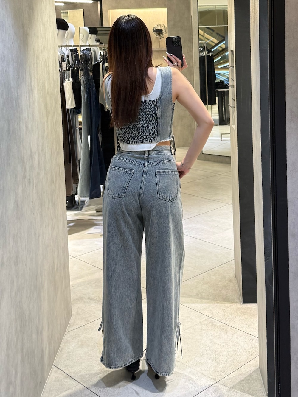 ホワイト系のニット/セーター、ブルー系のタンクトップ、ブルー系のデニムパンツを着用したレディースの春コーディネートの3枚目の写真