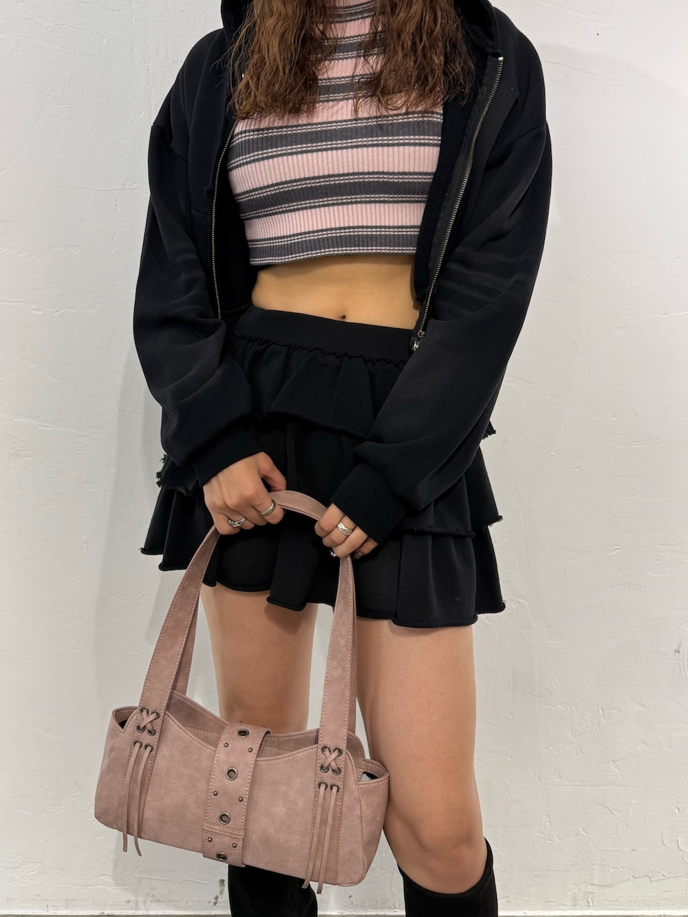 ピンク系のニット/セーター、ブラック系のパーカー、ブラック系のスカートを着用したレディースの秋コーディネートの6枚目の写真