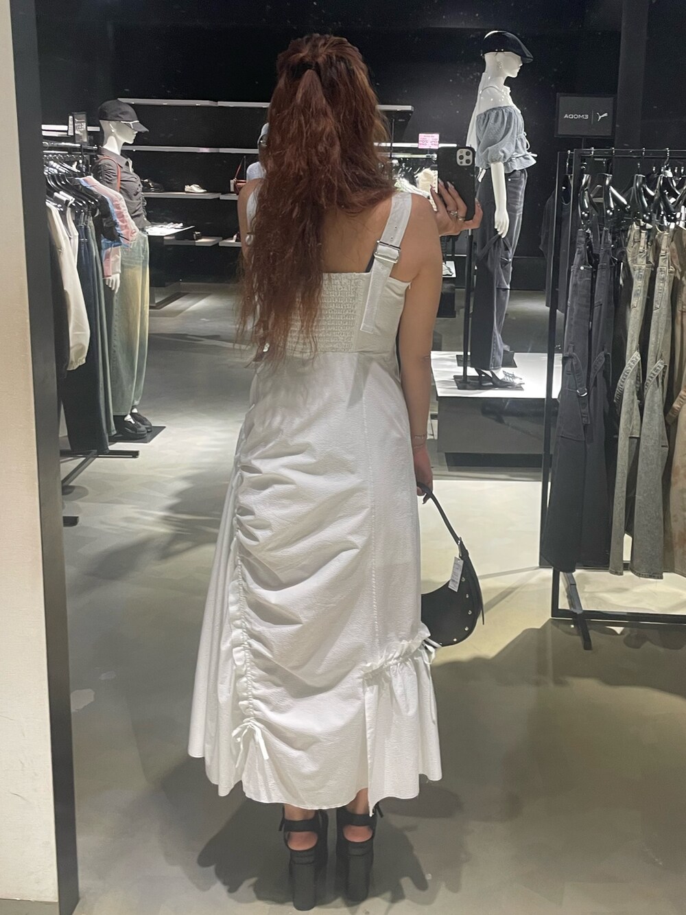 ブラック系のTシャツ/カットソー、ホワイト系のワンピース、ブラック系のハンドバッグを着用したレディースの春コーディネートの3枚目の写真