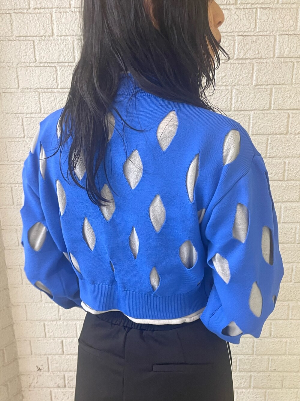 ブルー系のニット/セーター、ブラック系のスラックス、ブラック系のローファーを着用したレディースの冬コーディネートの6枚目の写真