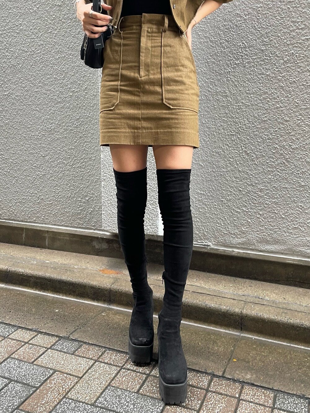 ブラウン系のシャツ/ブラウス、ブラック系のTシャツ/カットソー、ブラック系のハンドバッグを着用したレディースの秋コーディネートの5枚目の写真