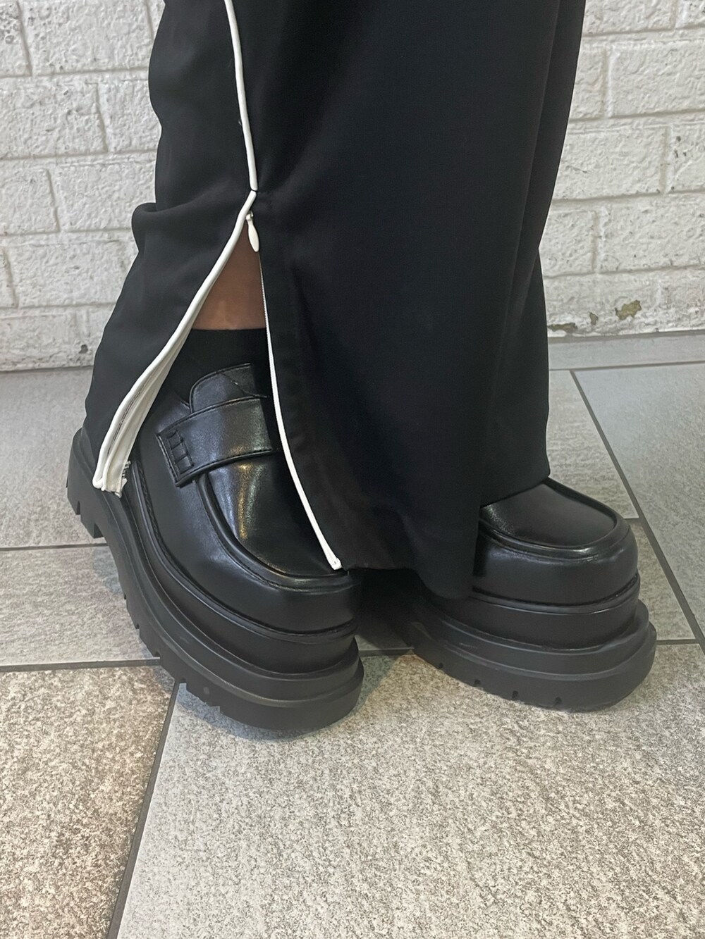 ブルー系のニット/セーター、ブラック系のスラックス、ブラック系のローファーを着用したレディースの冬コーディネートの9枚目の写真